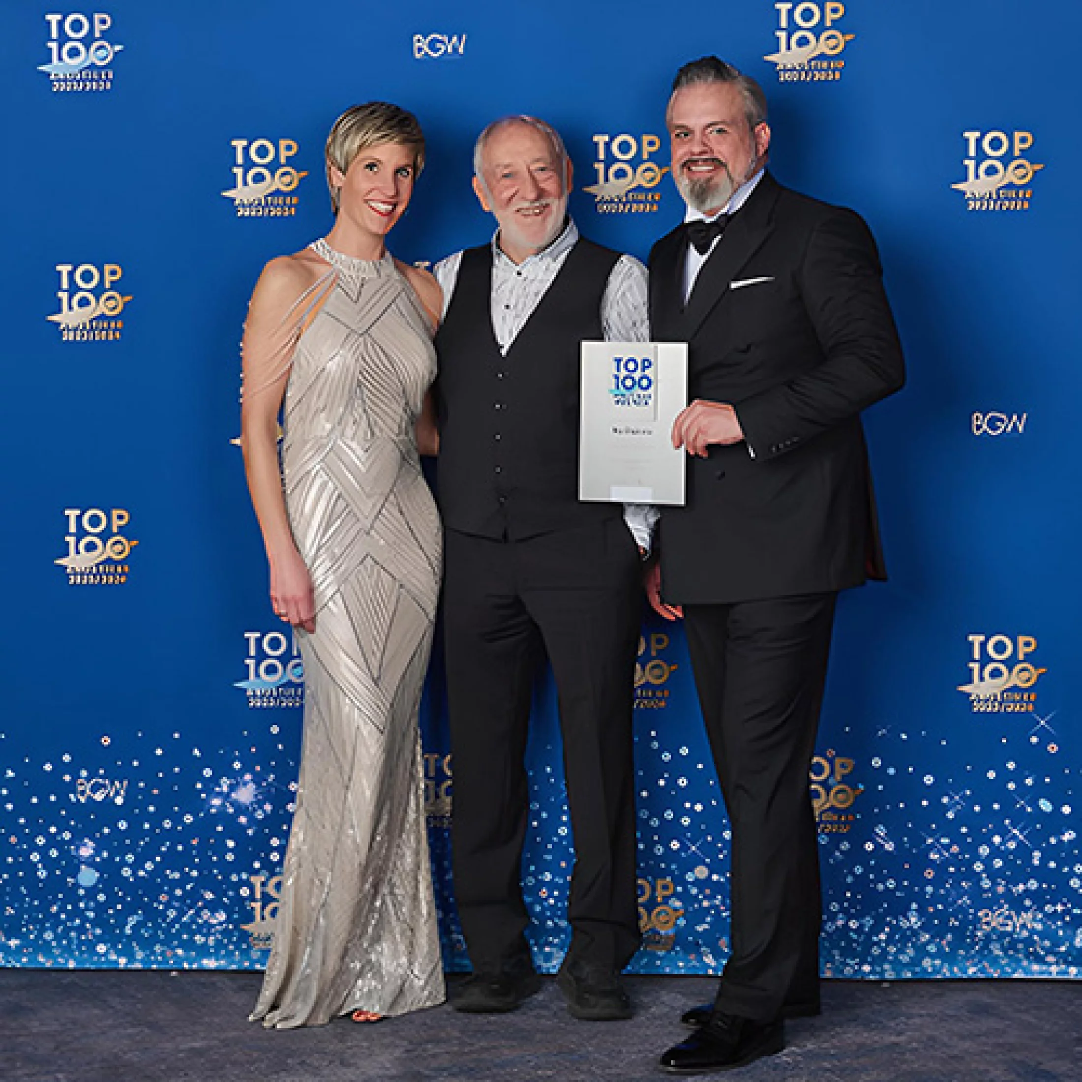 Drei Personen bei Top 100 Hörakustiker Auszeichnung mit Urkunde