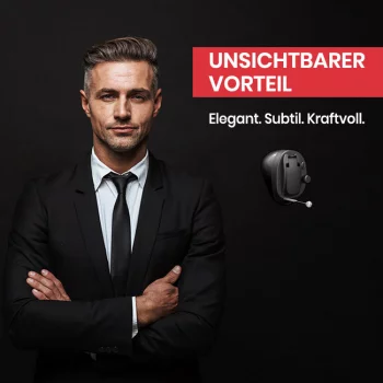 Mann im Anzug mit unsichtbarem Hörgerät vor schwarzem Hintergrund