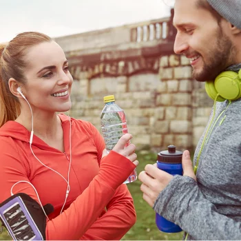 Frau und Mann mit Kopfhörern beim Sport im Freien​​​​​​
