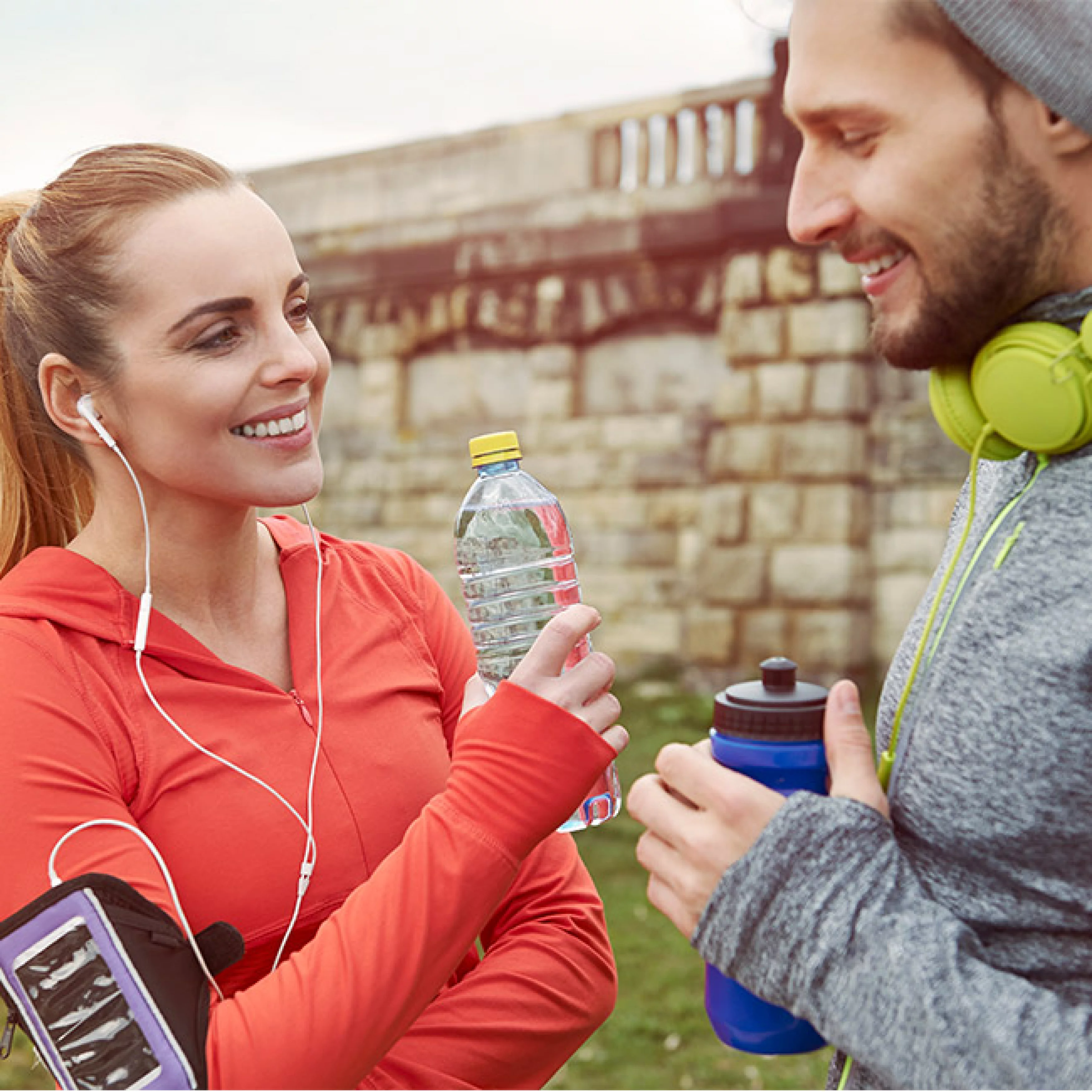 Frau und Mann mit Kopfhörern beim Sport im Freien​​​​​​