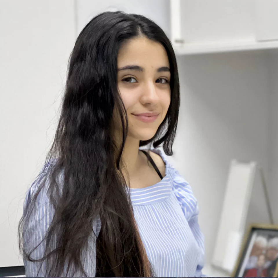 Junge Frau mit langem Haar in heller Bluse im Innenraum