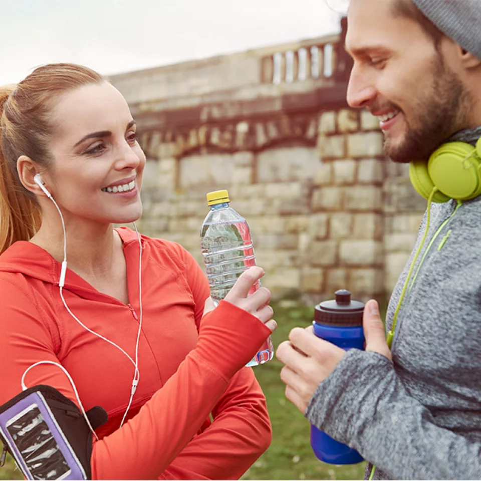 Frau und Mann mit Kopfhörern beim Sport im Freien​​​​​​